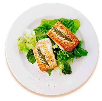 Dos filetes de pescado a la parrilla sobre una cama de lechuga verde en un plato blanco.