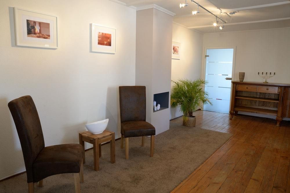 Ein Wartezimmer mit zwei Stühlen und einer Pflanze