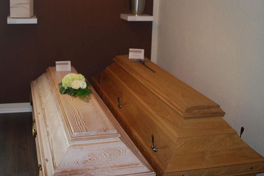 Zwei Holzsärge stehen nebeneinander in einem Raum