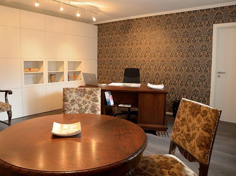 Ein Raum mit einem Tisch und Stühlen und einem Schreibtisch mit einem Laptop darauf