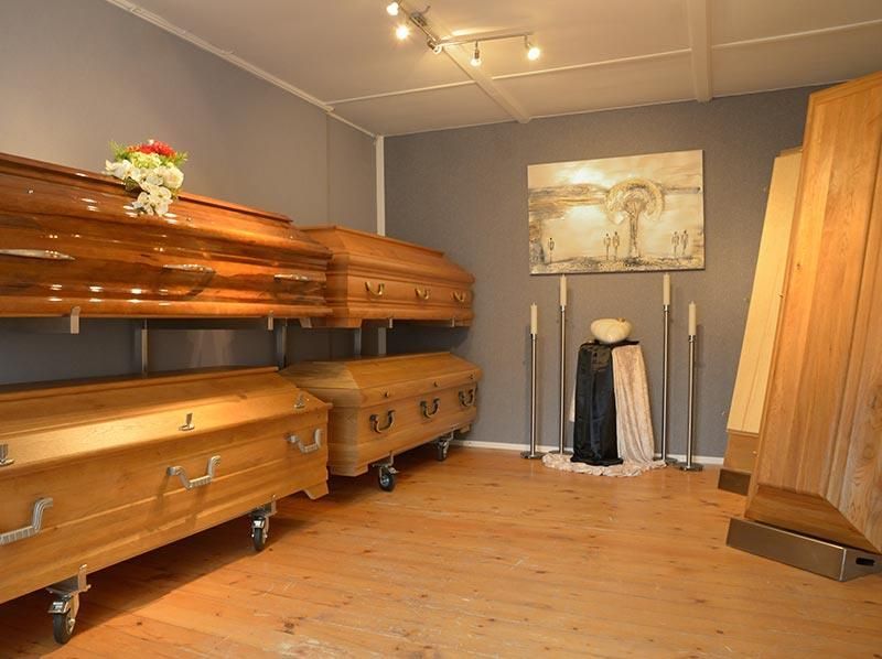 Ein Raum voller Holzsärge und ein Bild an der Wand