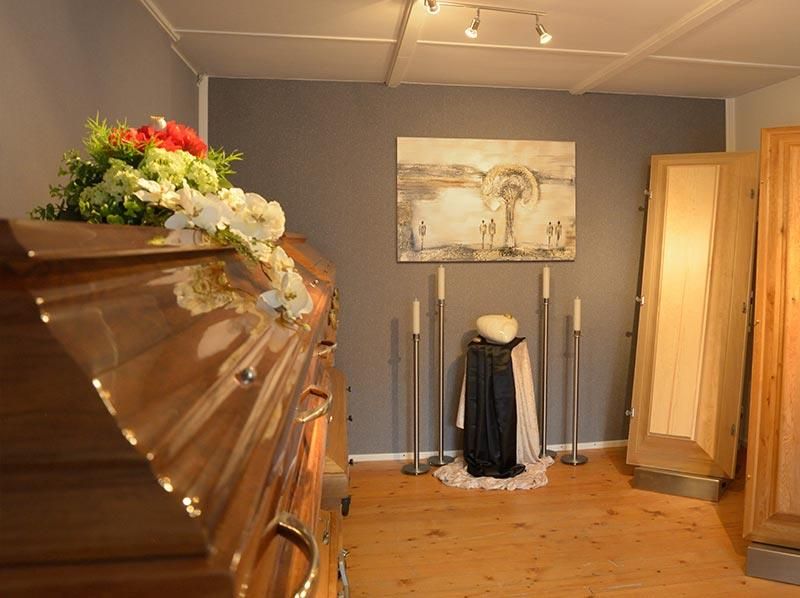 Ein Raum mit einem Sarg und einem Gemälde an der Wand