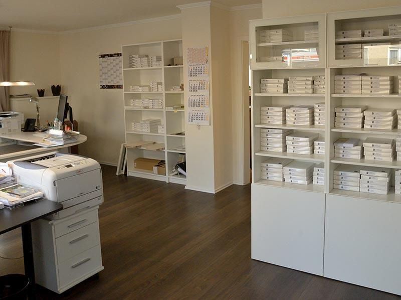 Ein Raum mit einem Drucker und Regalen voller Bücher