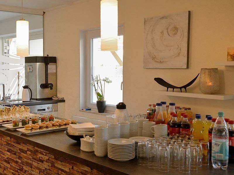 Eine Theke mit Tellern und Gläsern und Limonadenflaschen darauf