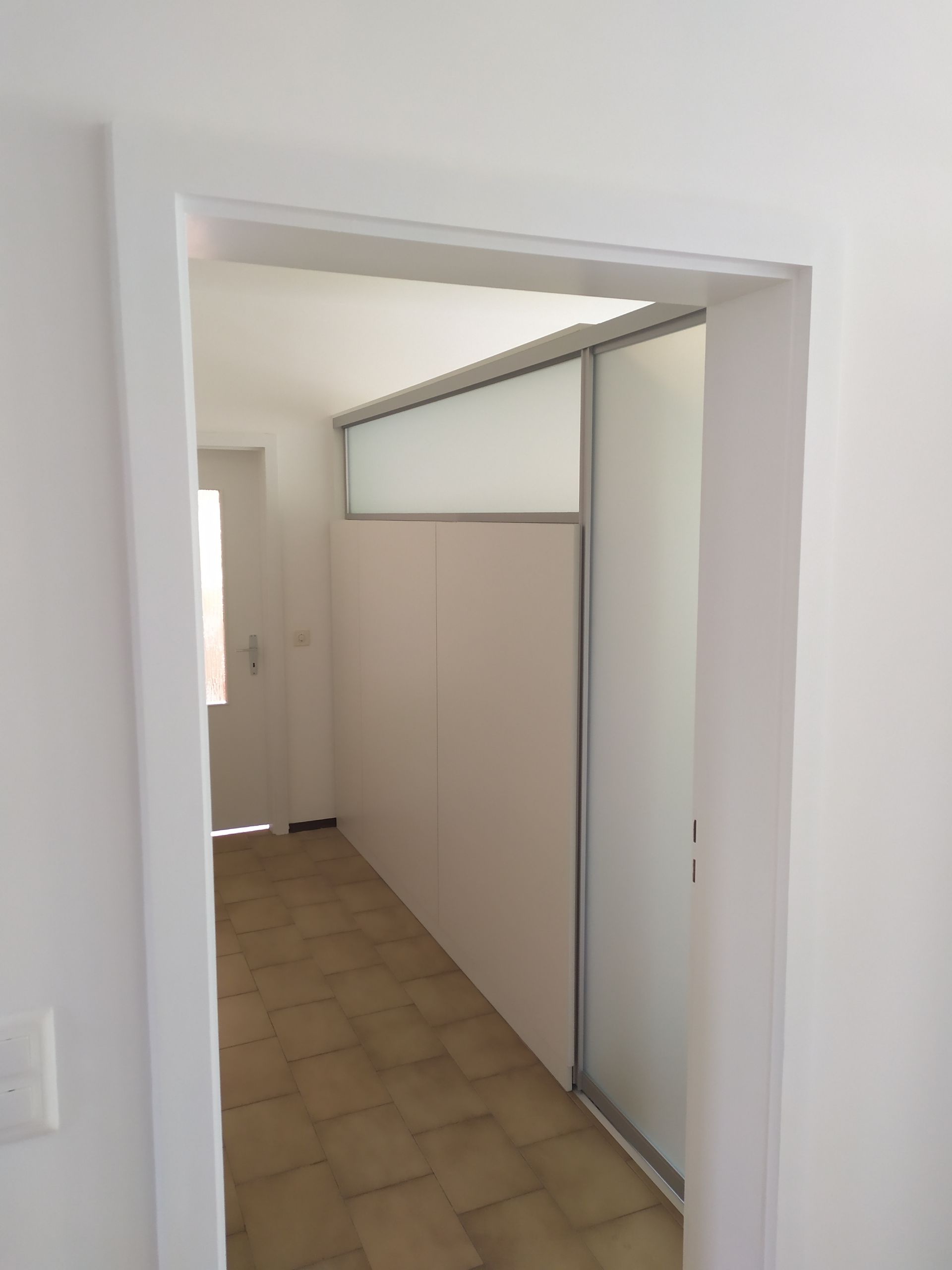 armadio bianco a 5 ante, telaio in alluminio con vetro nella parte superiore. Anta scorrevole in alluminio e vetro. In posizione aperta viene nascosta  nell'intercapedine dell'armadio. (vetri di sicurezza satinati bianchi)