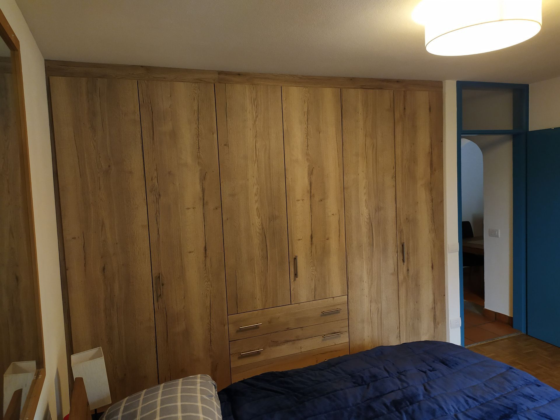 armadio a muro, ante finitura Swisskrono rovere rustico, Interno bianco, cassettiera con cassetti a vista, ripiani spostabili e tubo appendi abiti. Chiusure perimetrali.