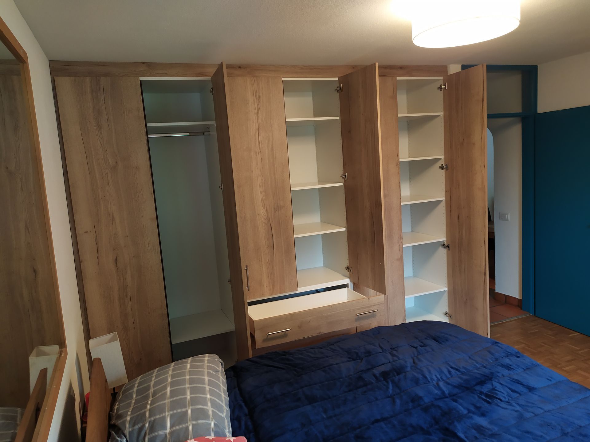 armadio a muro, ante finitura Swisskrono rovere rustico, Interno bianco, cassettiera con cassetti a vista, ripiani spostabili e tubo appendi abiti. Chiusure perimetrali.