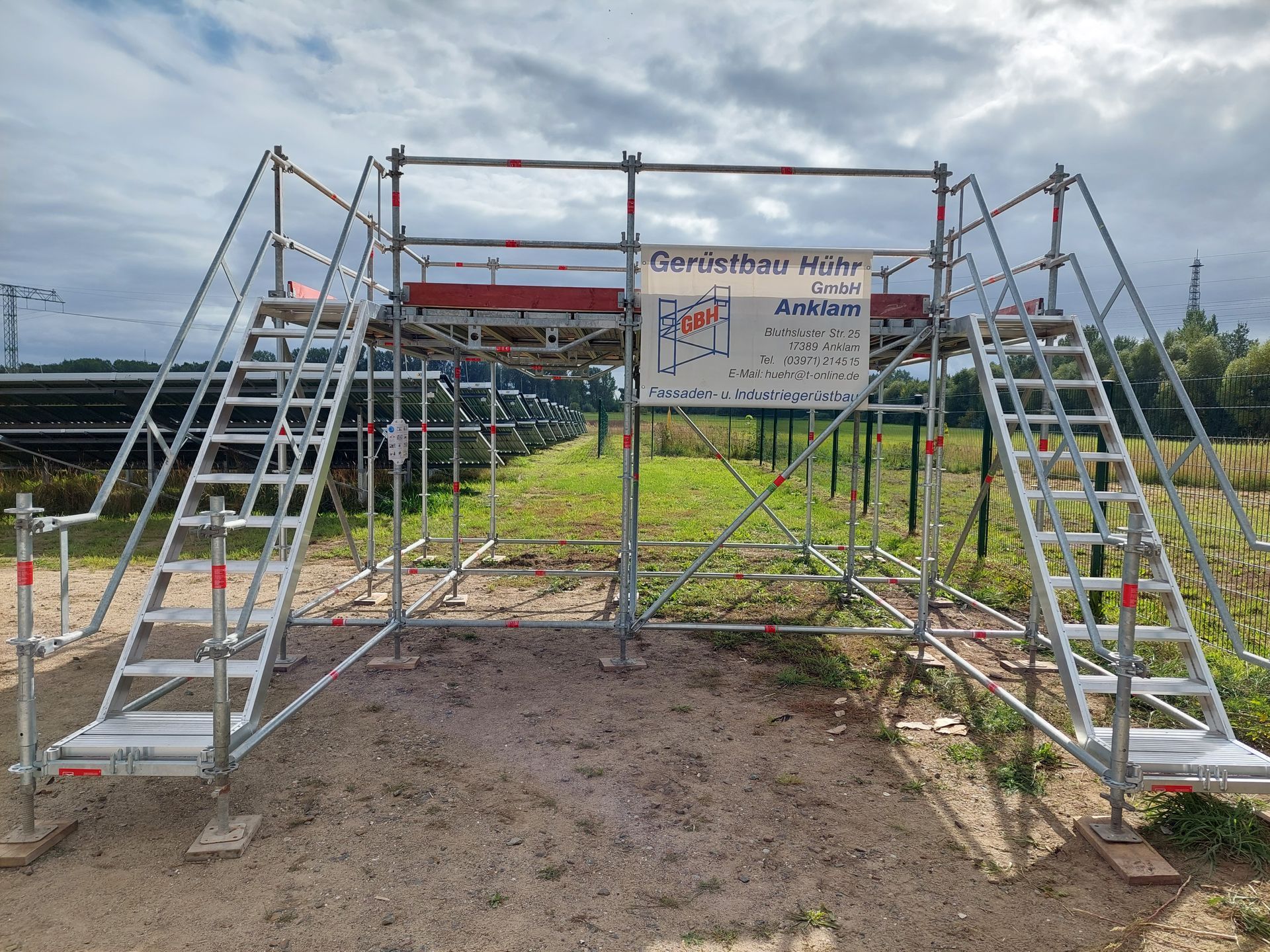 Eine Gerüstkonstruktion mit Treppen und einem Schild mitten auf einem Feld.
