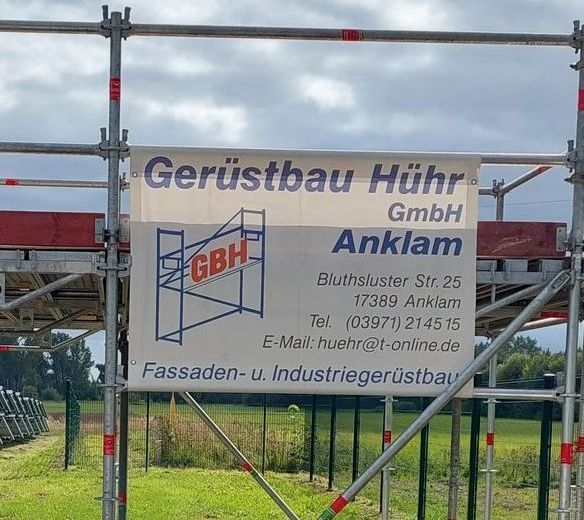 A sign on a scaffolding says gerüstbau hühr gmbh anklam