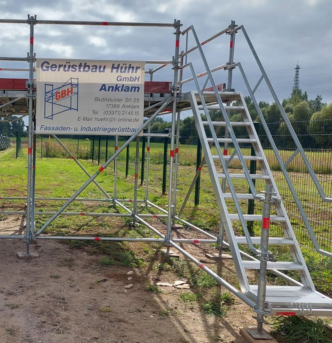 Eine Gerüstkonstruktion mit Treppen und einem Schild mit der Aufschrift „Gerüstbau hoch“
