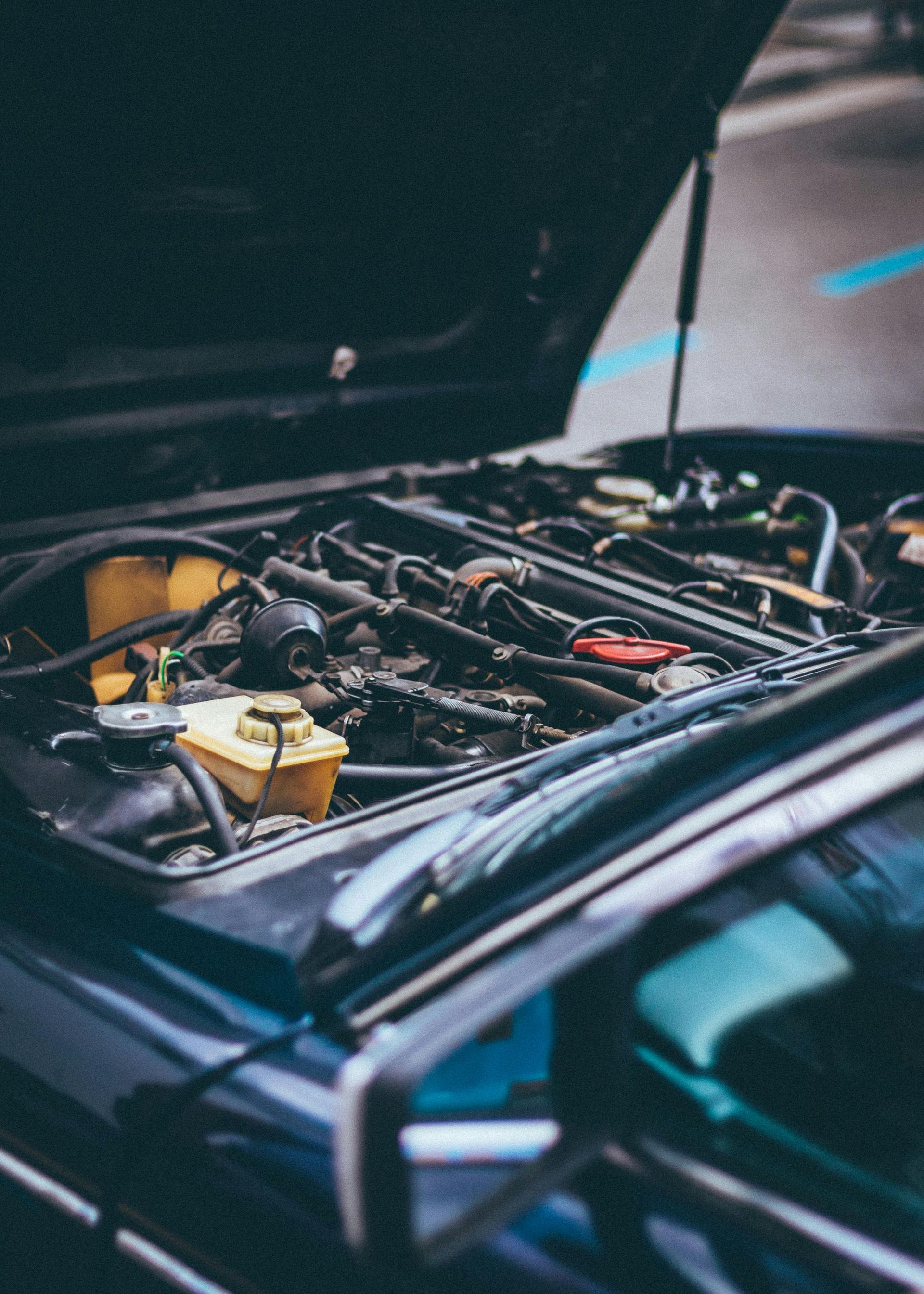 Die Motorhaube eines Autos ist geöffnet und der Motor ist sichtbar.