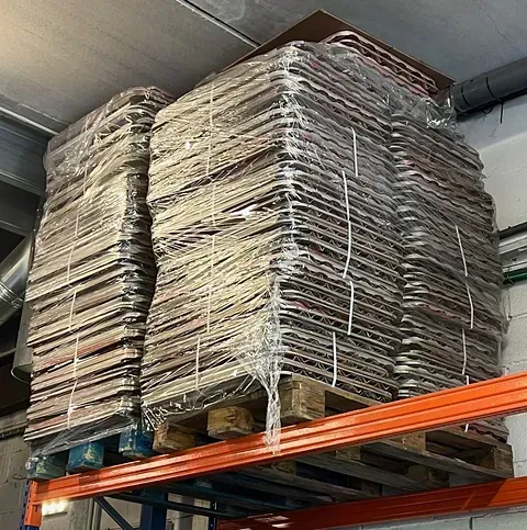 Una pila de cajas de cartón colocadas encima de una paleta en un estante.
