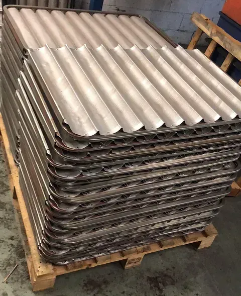 Una pila de bandejas de metal sobre un palé de madera