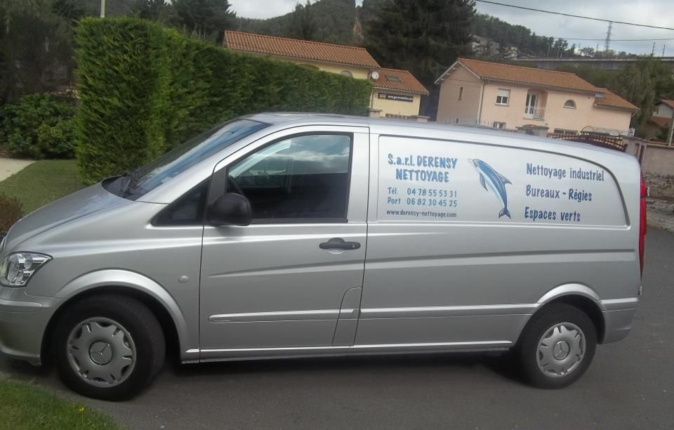 Un véhicule garé dans une rue arbore le logo et les coordonnées de l'entreprise.