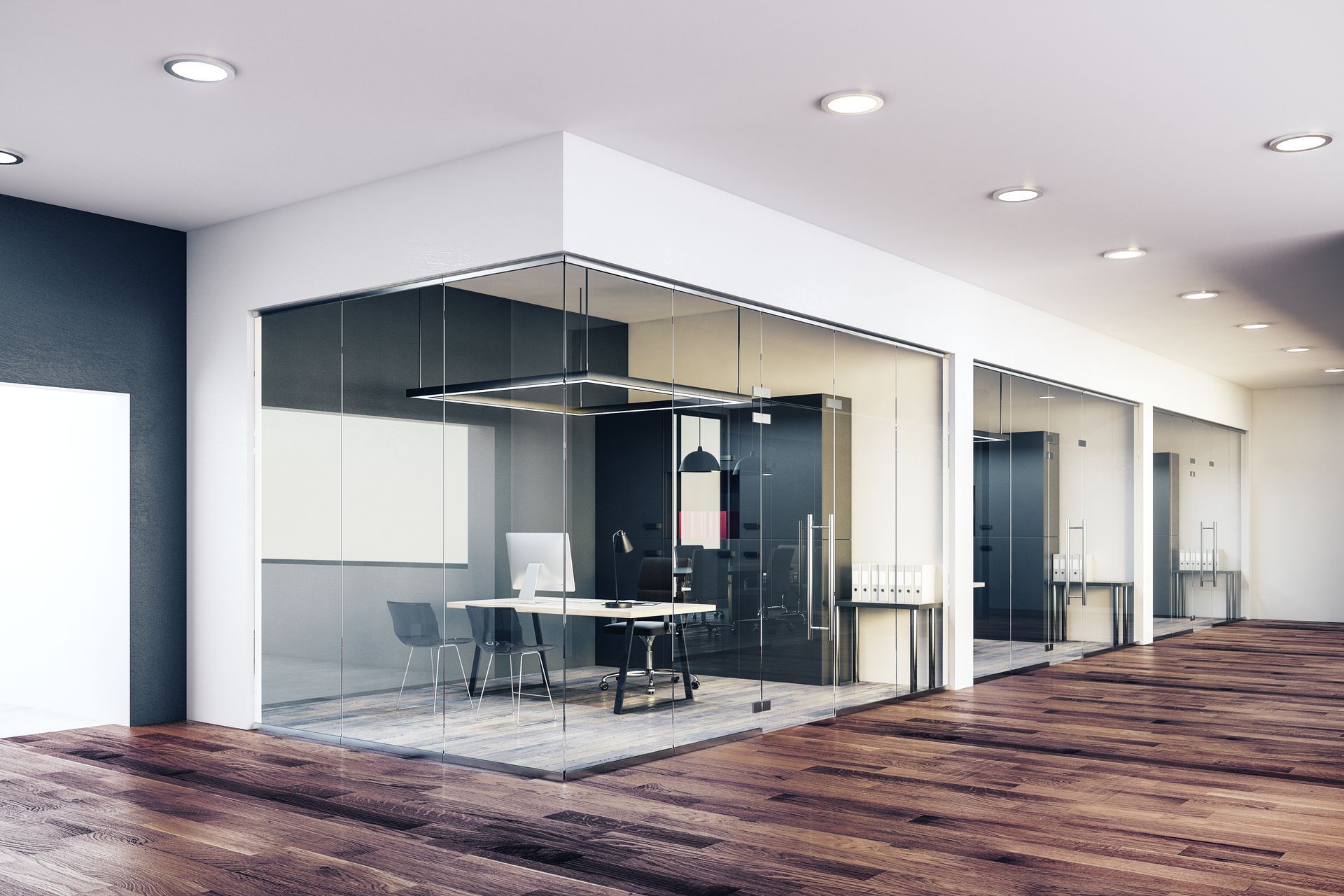 Un intérieur de bureau moderne avec des salles de réunion aux parois vitrées et des bureaux individuels.