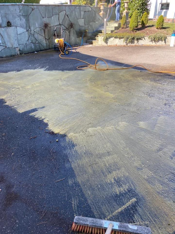 Une personne nettoie au nettoyeur à haute pression une terrasse.