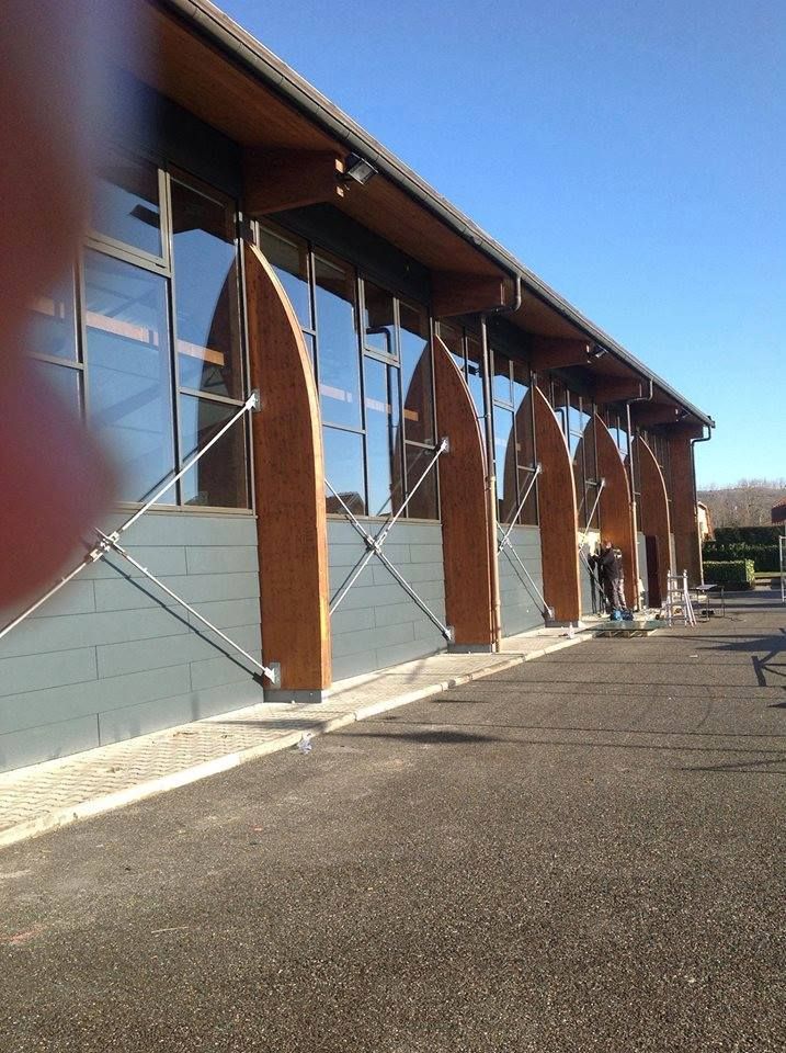 Façade vitrée et poutres bois d'un bâtiment.