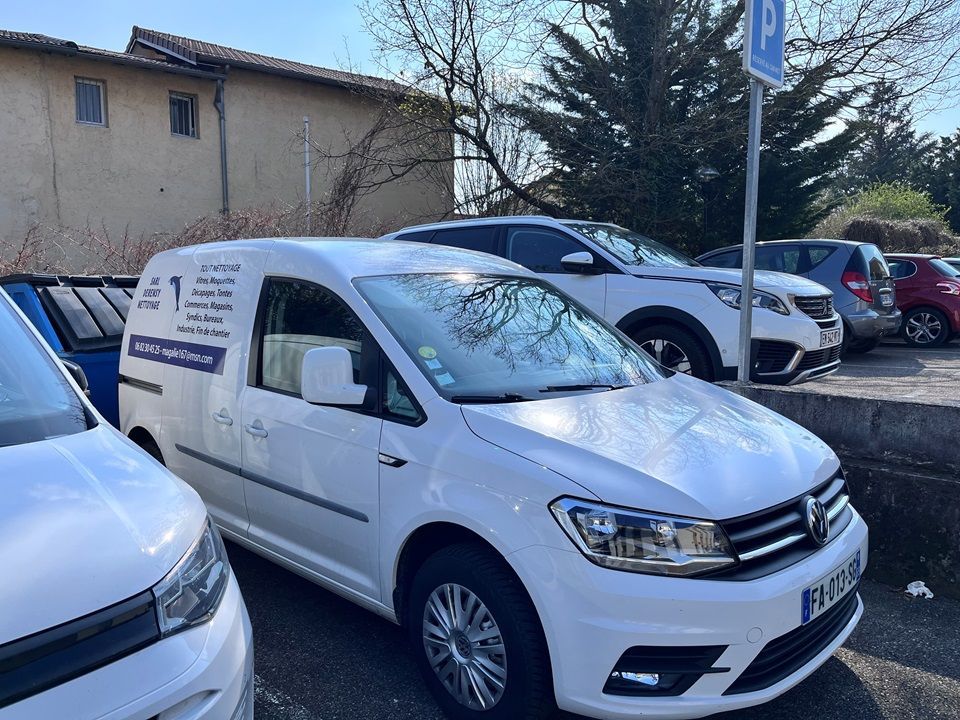 Une camionnette Volkswagen Caddy blanche garée sur un parking par une journée ensoleillée.