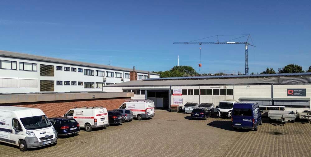 Vor einem Gebäude parkt eine Reihe Lieferwagen.