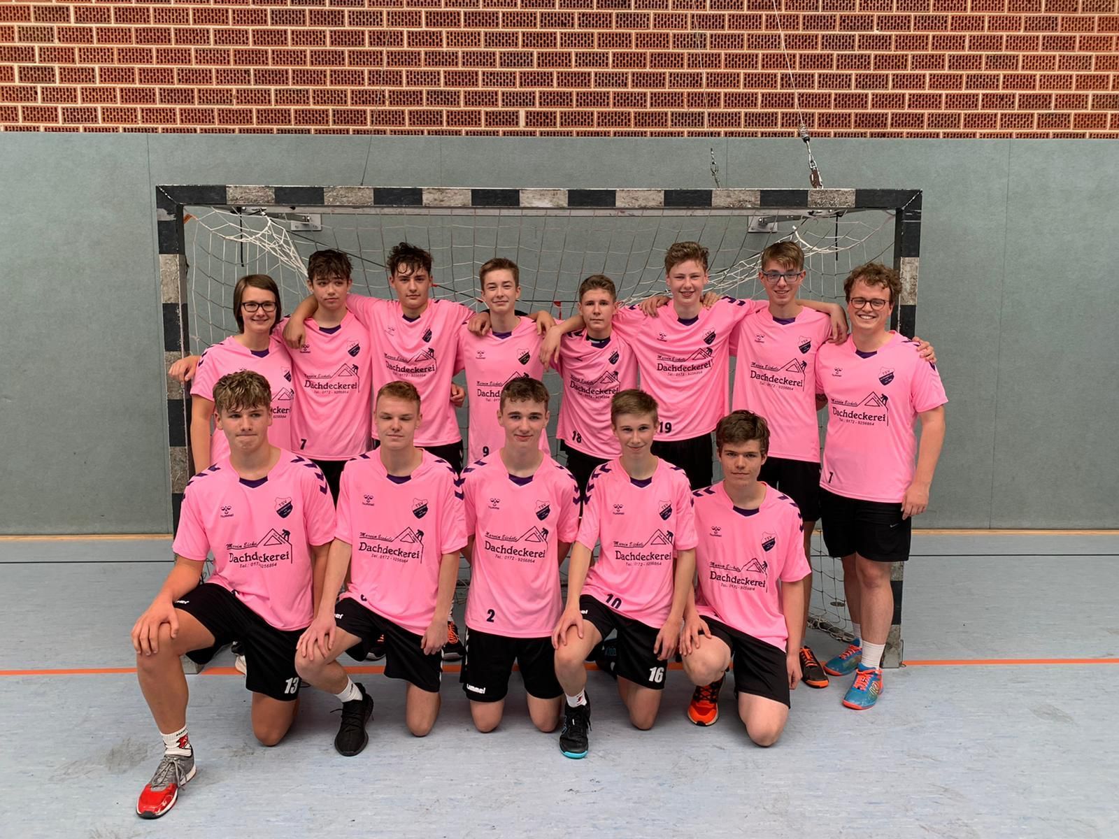 Eine Gruppe junger Männer in rosa Hemden posiert für ein Foto.