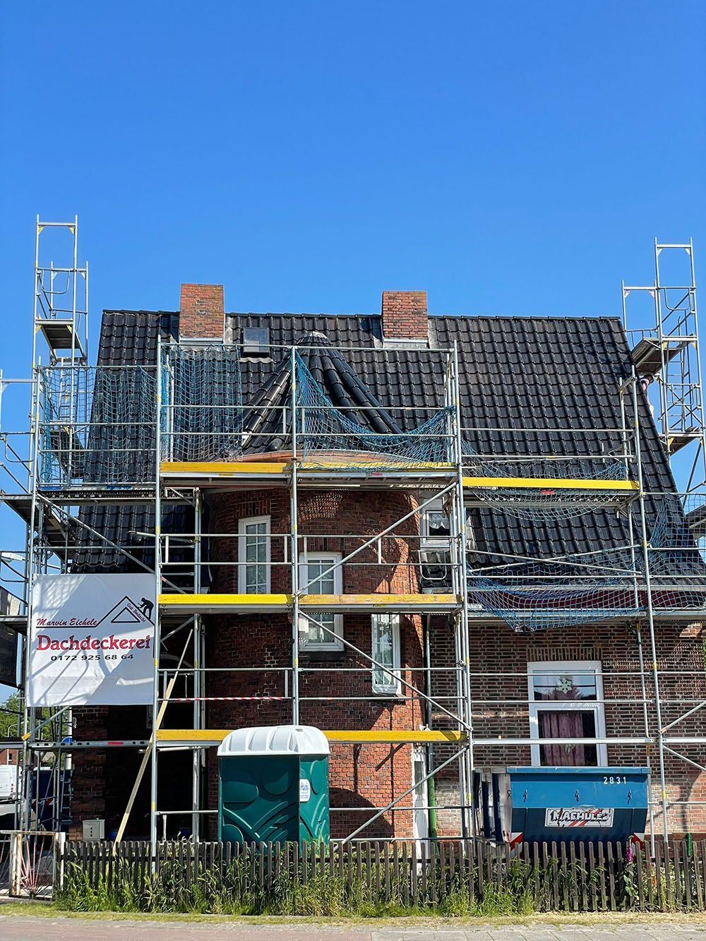 Ein Backsteinhaus wird umgebaut und ist von einem Gerüst umgeben.