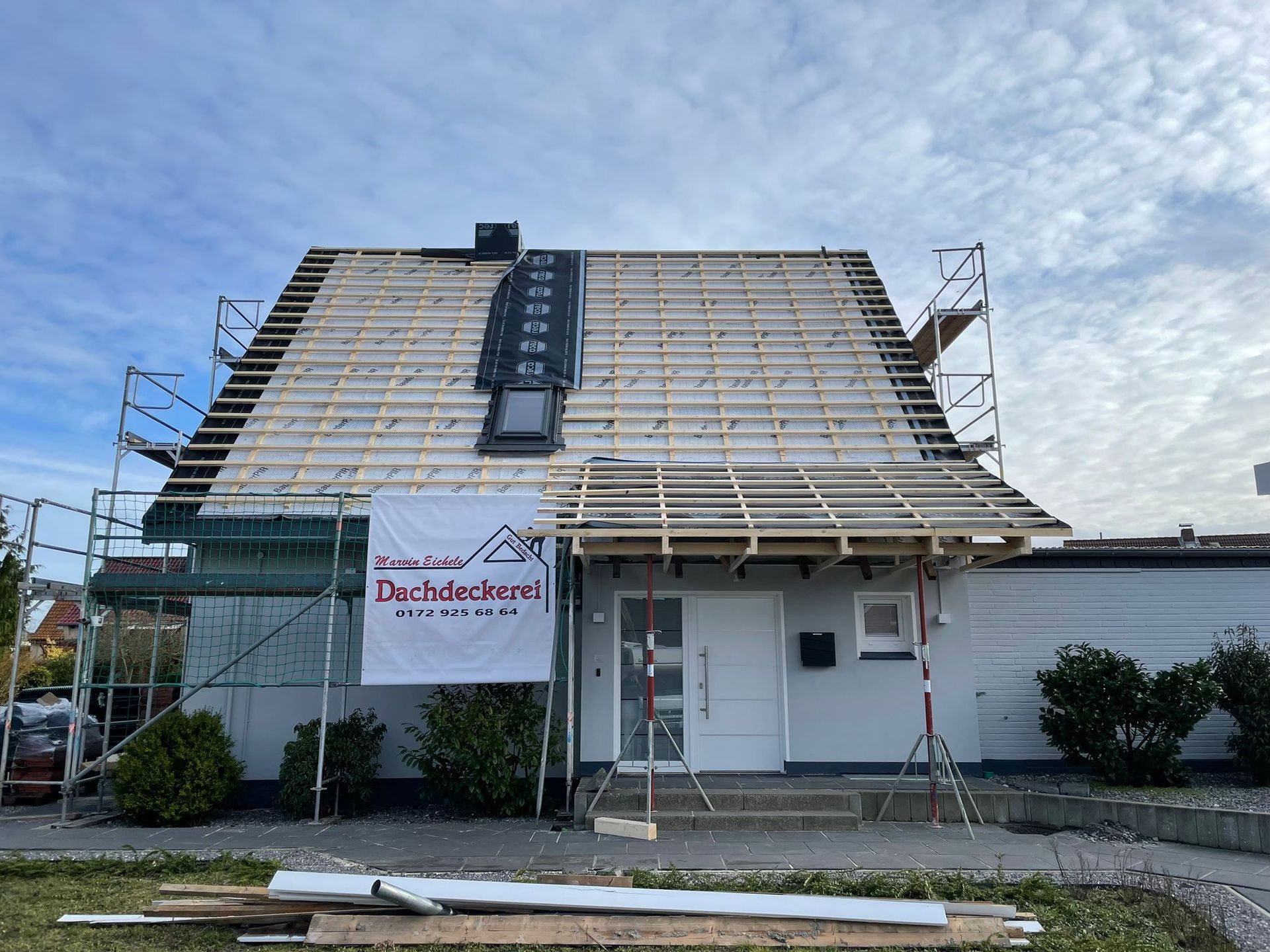 Das Dach eines Hauses wird gebaut und an der Seite des Hauses befindet sich ein Schild.