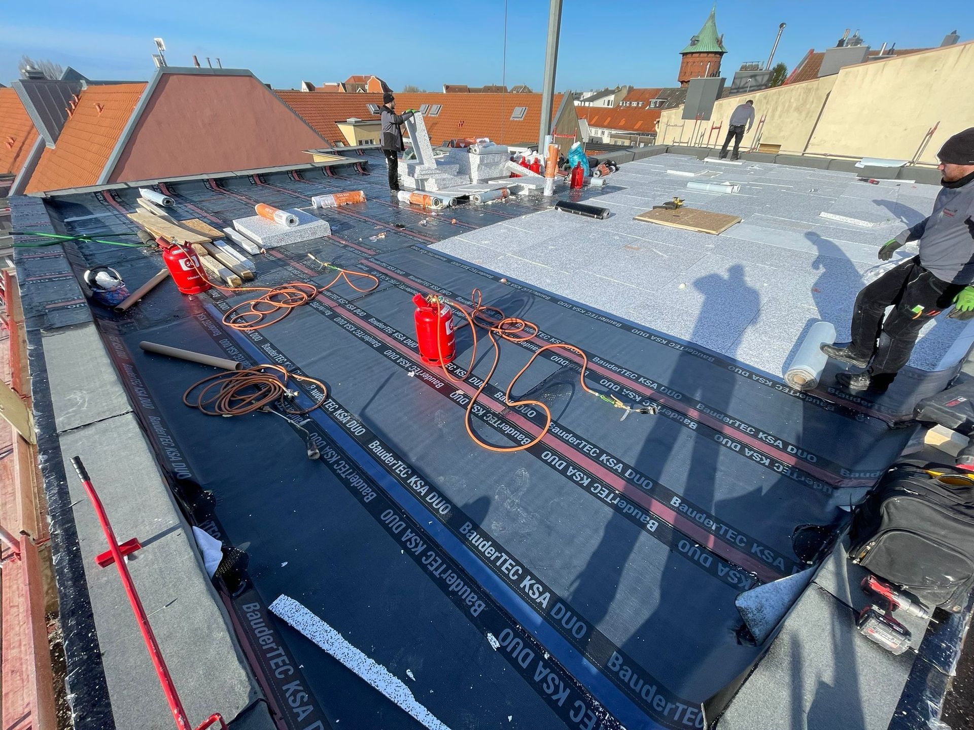 Ein Mann arbeitet auf dem Dach eines Gebäudes.