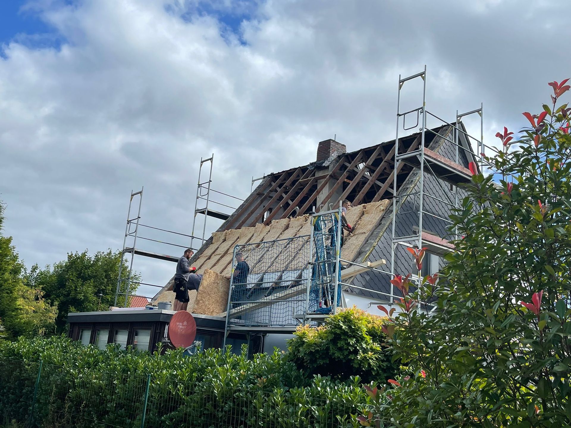 Ein Haus wird mit einem Gerüst auf dem Dach umgebaut.