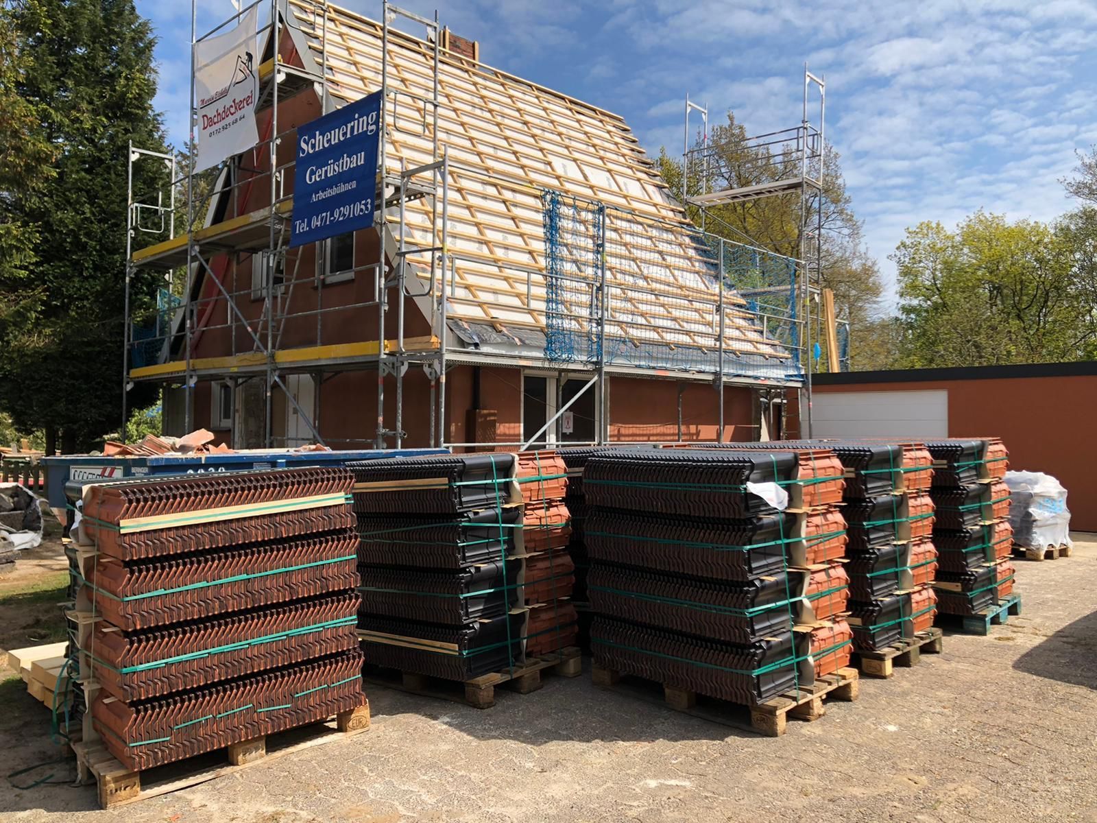 Ein Stapel Ziegelsteine ​​liegt vor einem im Bau befindlichen Gebäude.
