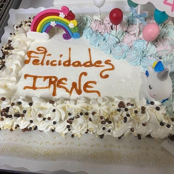 Una tarta rectangular cubierta de glaseado blanco, con la inscripción 
