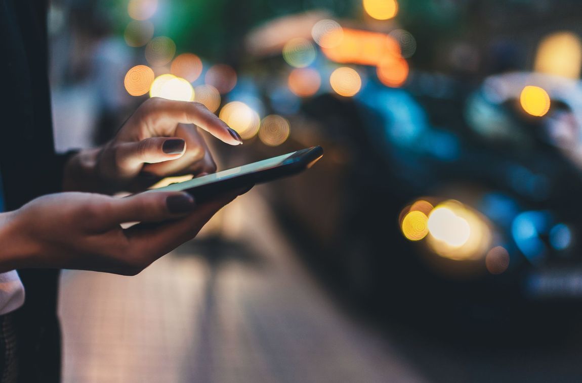 Main manucurée avec un téléphone portable de nuit
