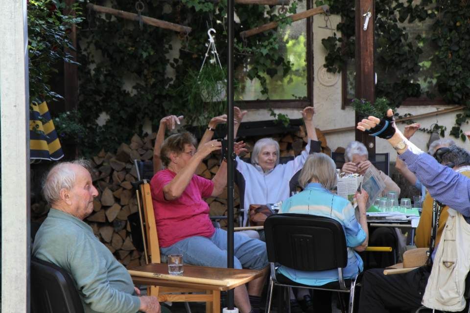 Gesellschaft sitzt gemeinsam am Tisch