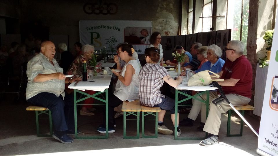 Gesellschaft sitzt gemeinsam am Tisch