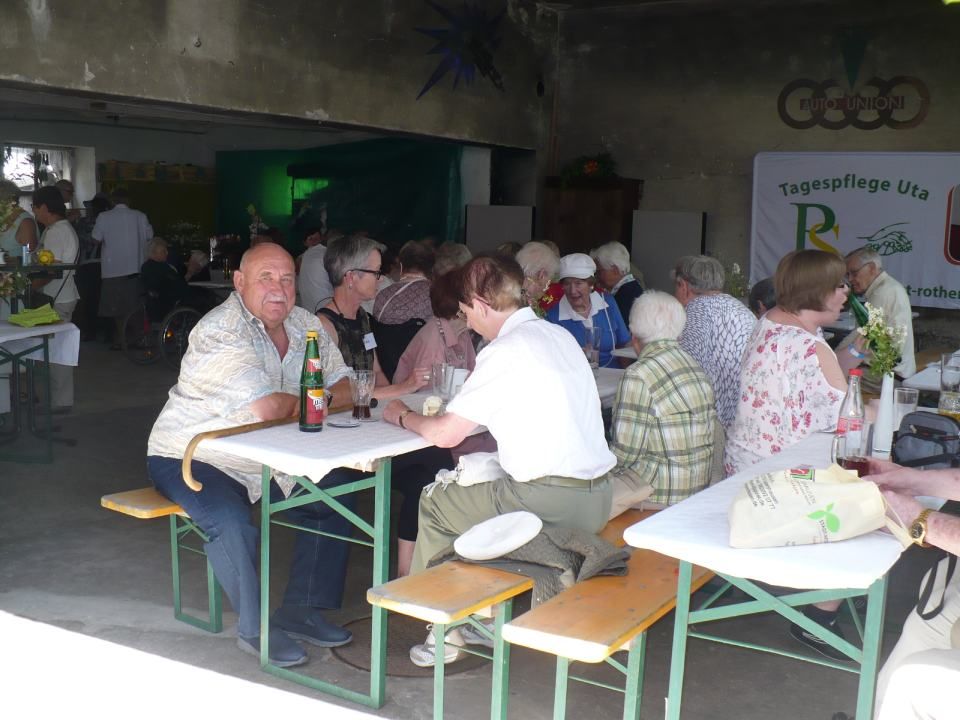 Gesellschaft sitzt gemeinsam am Tisch