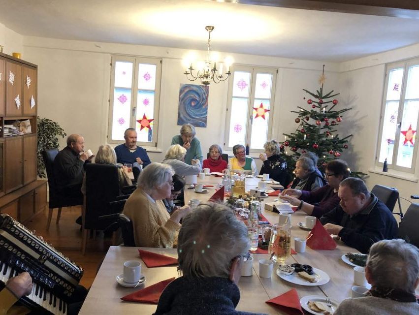 Senioren feiern gemeinsam Weihnachten am gedeckten Tisch