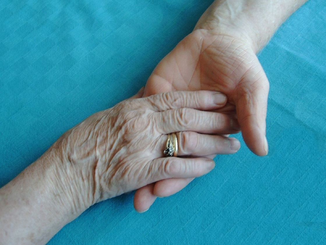 Seniorin sitzt am Tisch