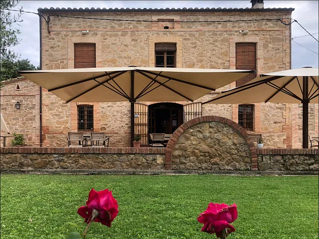 Un gran edifici de pedra amb para-sols davant