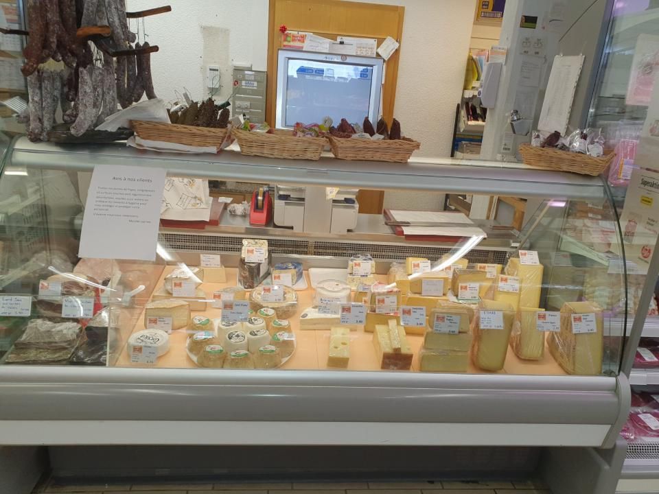 Une vitrine remplie d'une variété de fromages dans un magasin.