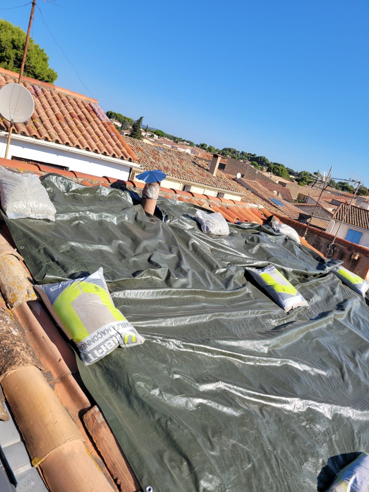 Toiture en cours de rénovation avec une bâche de protection