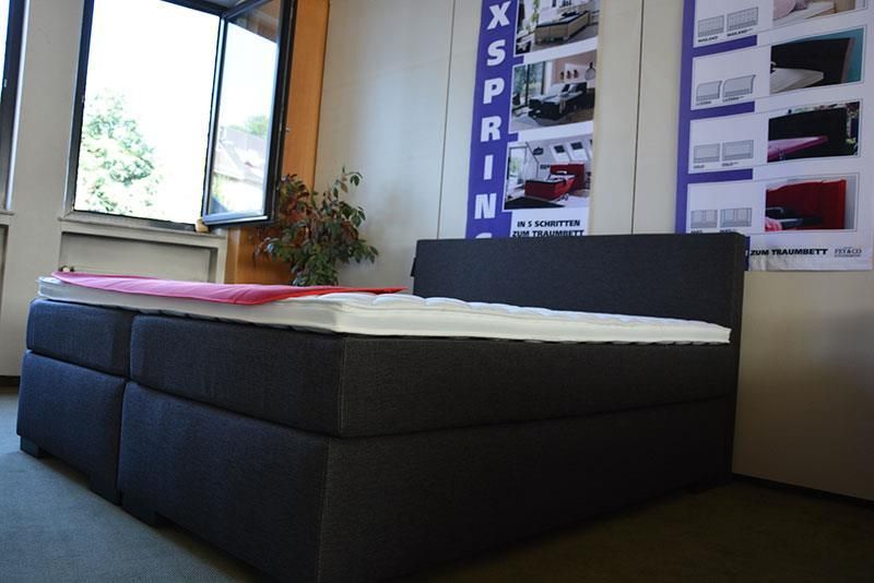 Ein Bett in einem Zimmer mit einem Schild mit der Aufschrift „Xsprin“