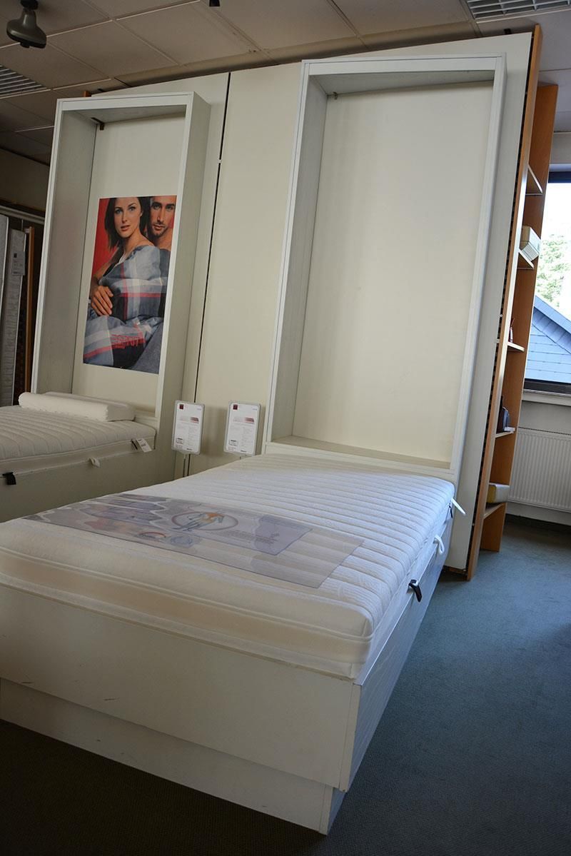 Ein Bett mit einem Familienbild an der Wand dahinter