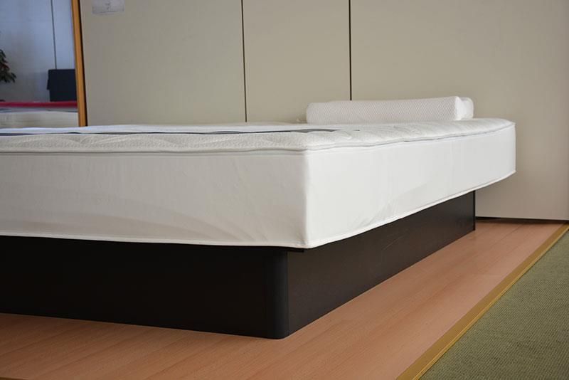 Eine weiße Matratze liegt auf einem Holzboden