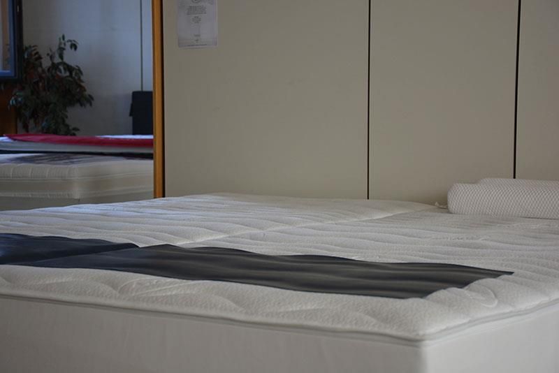 Auf einem Bett vor einem Spiegel liegt eine Matratze.