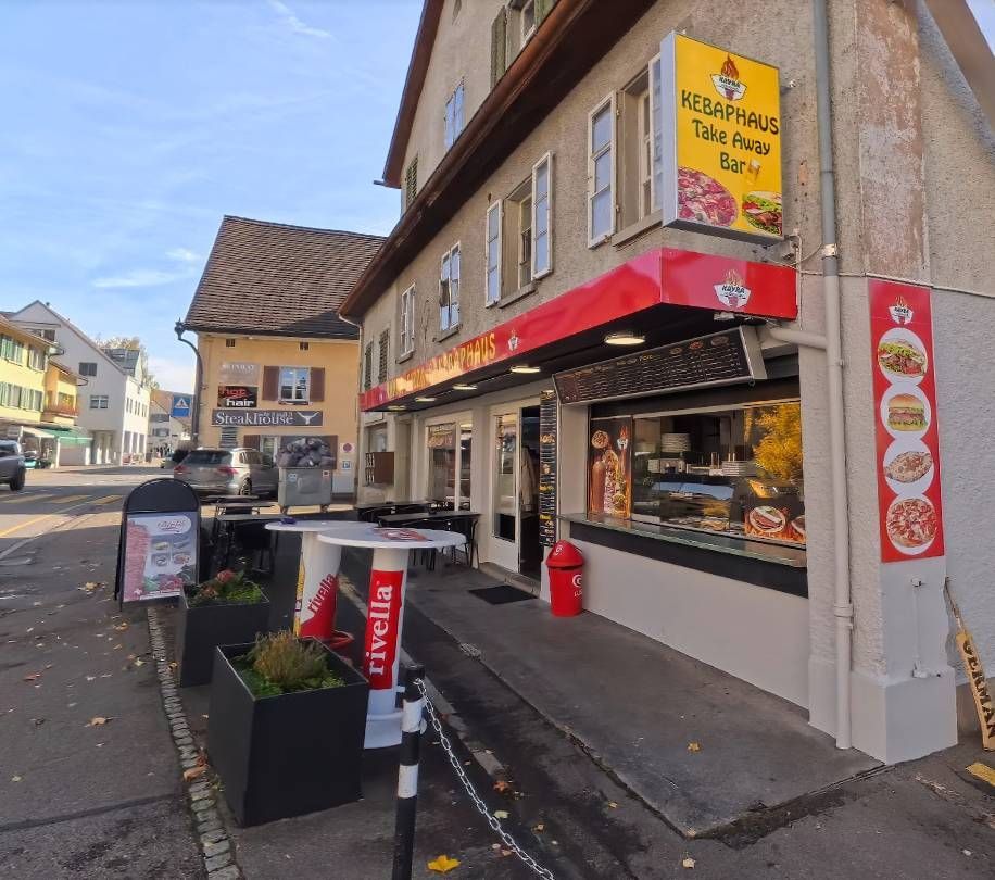 Kebab-Restaurant mit roter Markise, Rivella-Schild und Aussensitzplätzen an der Strasse.