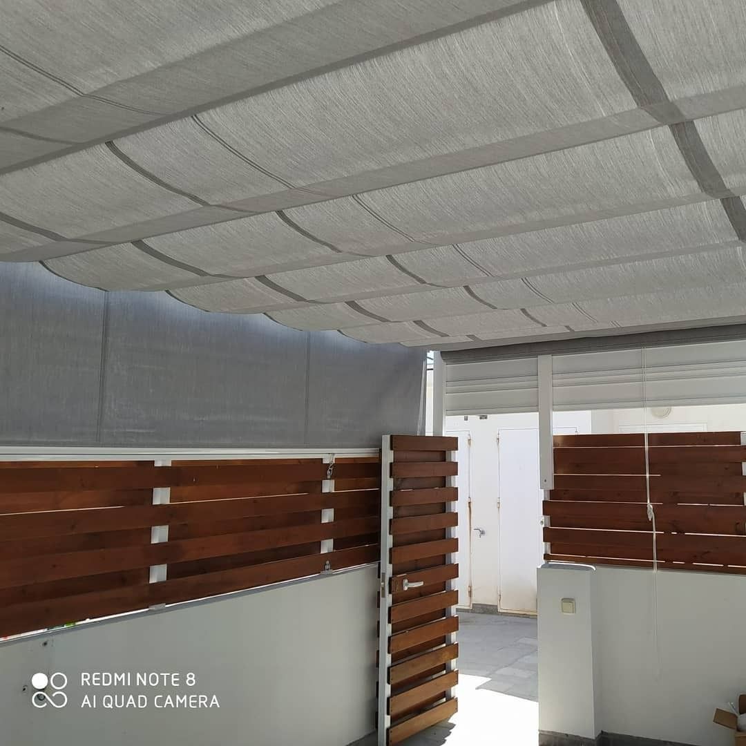 Una habitación con una valla de madera y un techo blanco.