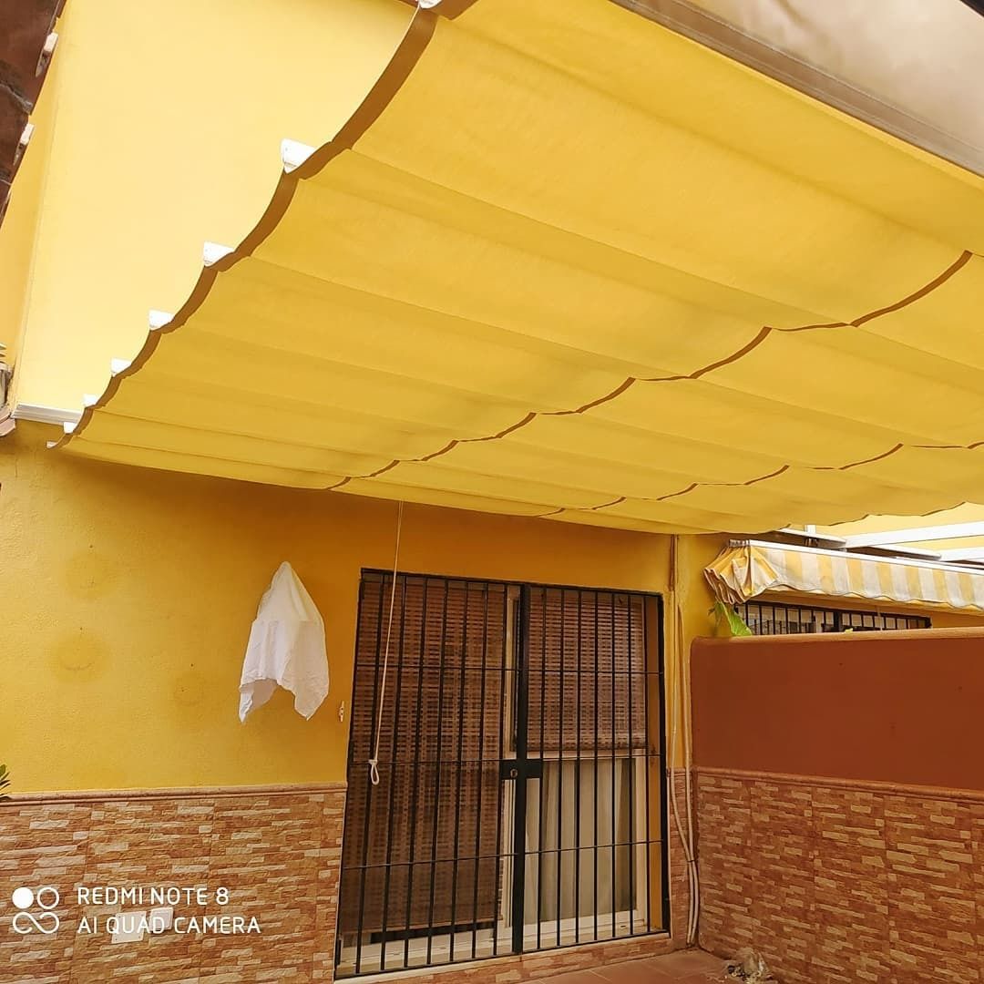 Un toldo amarillo cuelga del techo de un edificio.