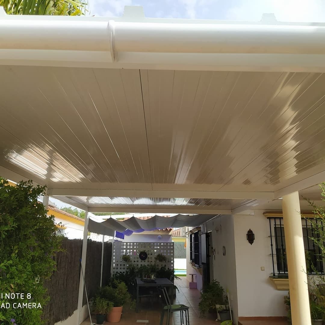 Una casa con techo blanco y canalón blanco.