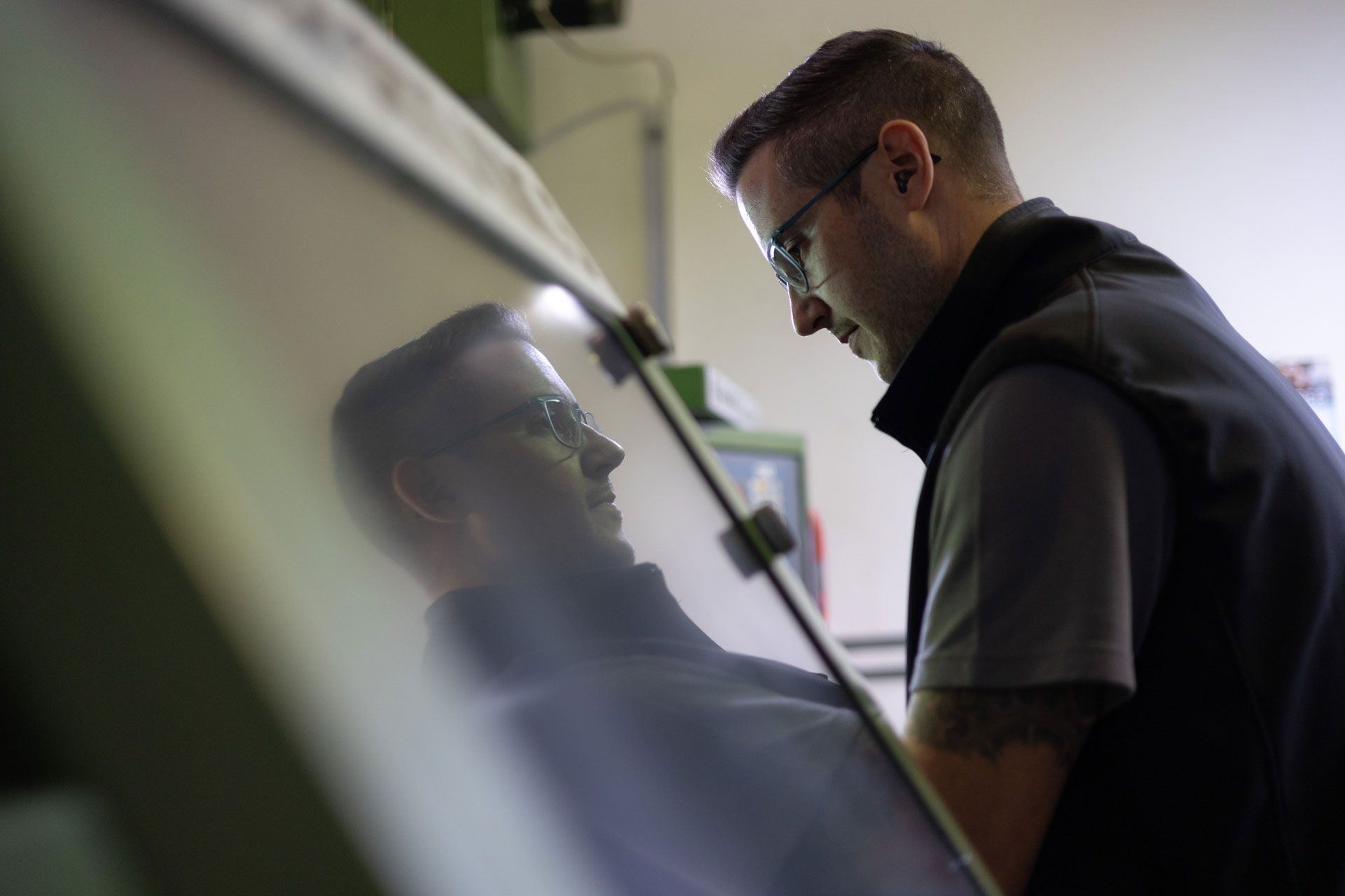 Ein Mann steht vor einem Computer und schaut auf einen Bildschirm .