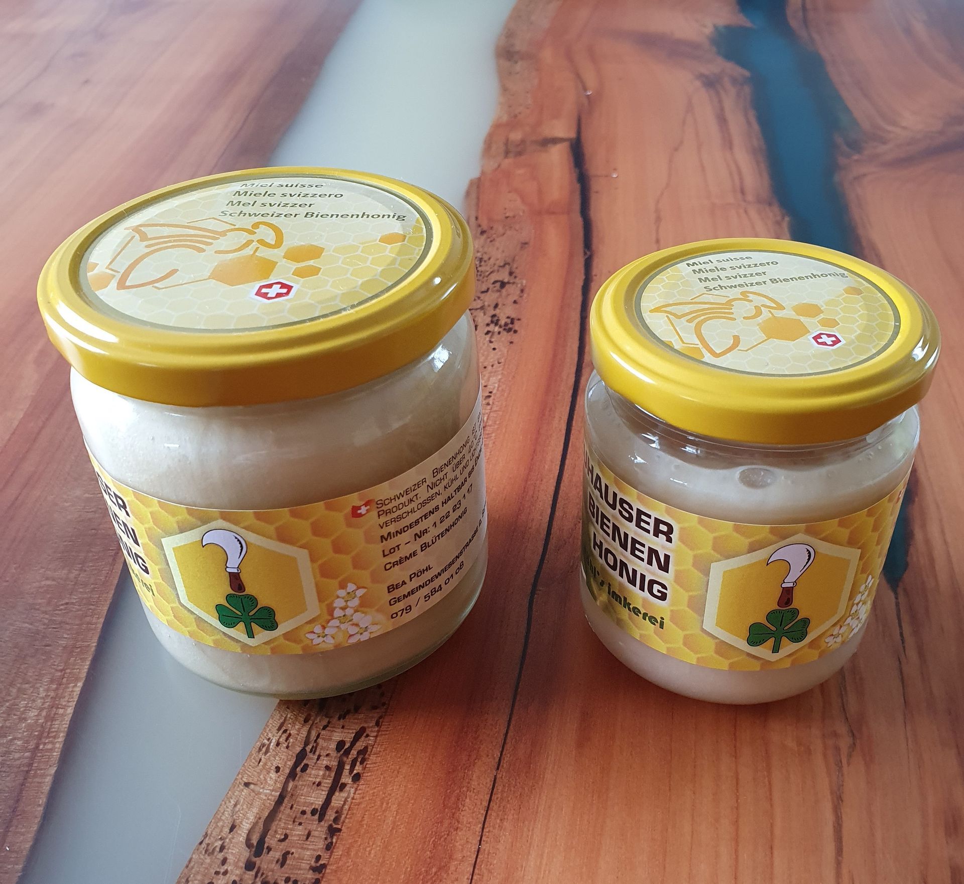 Eine Biene sammelt Pollen von einem Büschel kleiner rosa Blüten an einem Zweig.