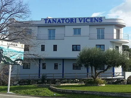 Un gran edificio blanco con la palabra tanatori vicens en la parte superior.